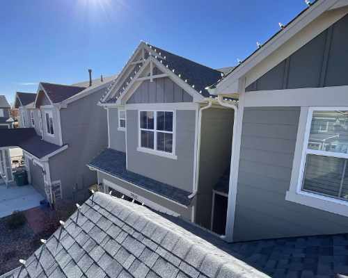 Townhouse with white Christmas lights strung along rooftop