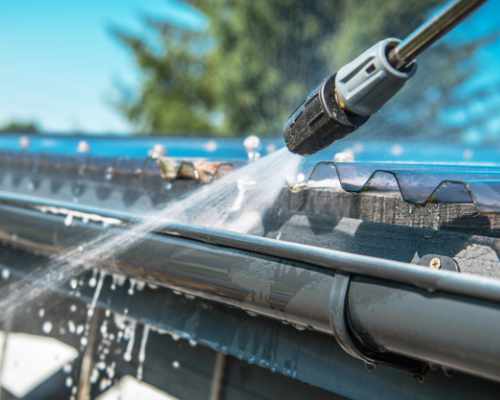 Pressure washer nozzle spraying aluminum rain gutters