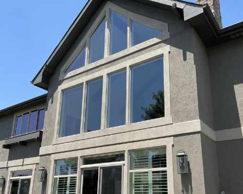 Reflective windows on multi-story home with stucco exterior